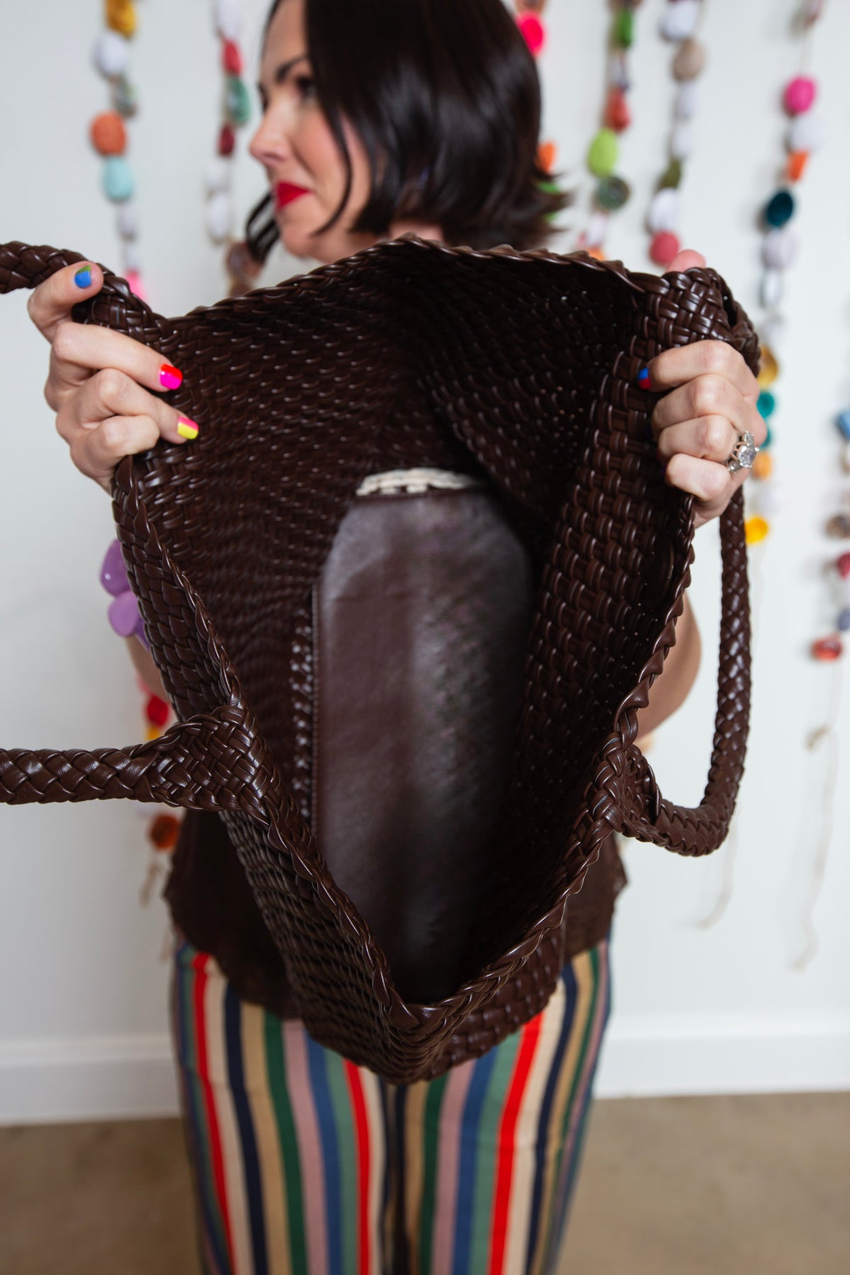Brown braided tote held open to show the roomy interior and inner pouch