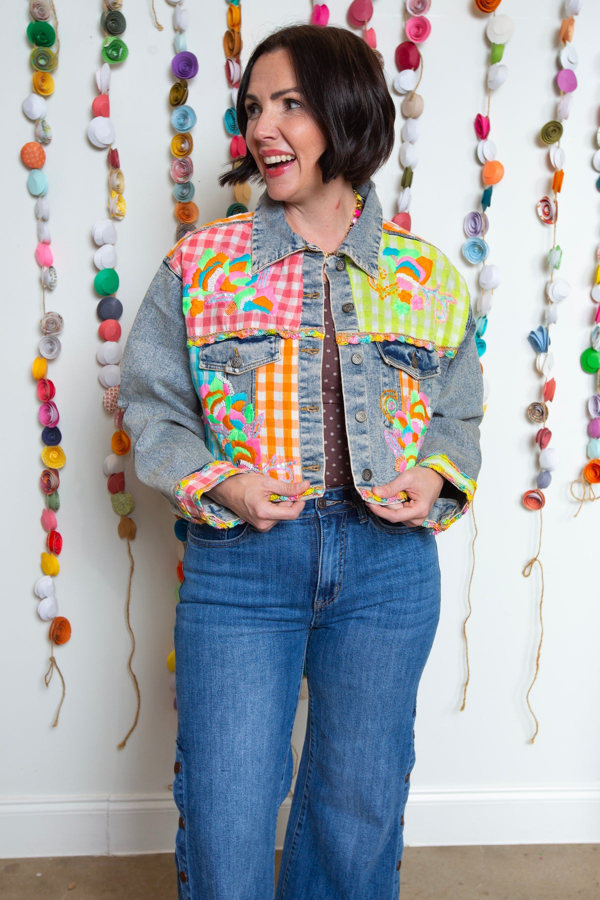 Emma Jean denim jacket buttoned up showing colorful neon embroidered front panels
