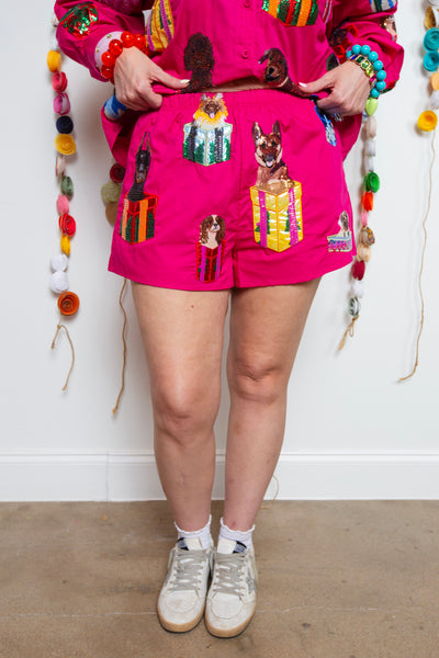 Hot pink Queen of Sparkles shorts with sequin dogs in present boxes worn with white sneakers