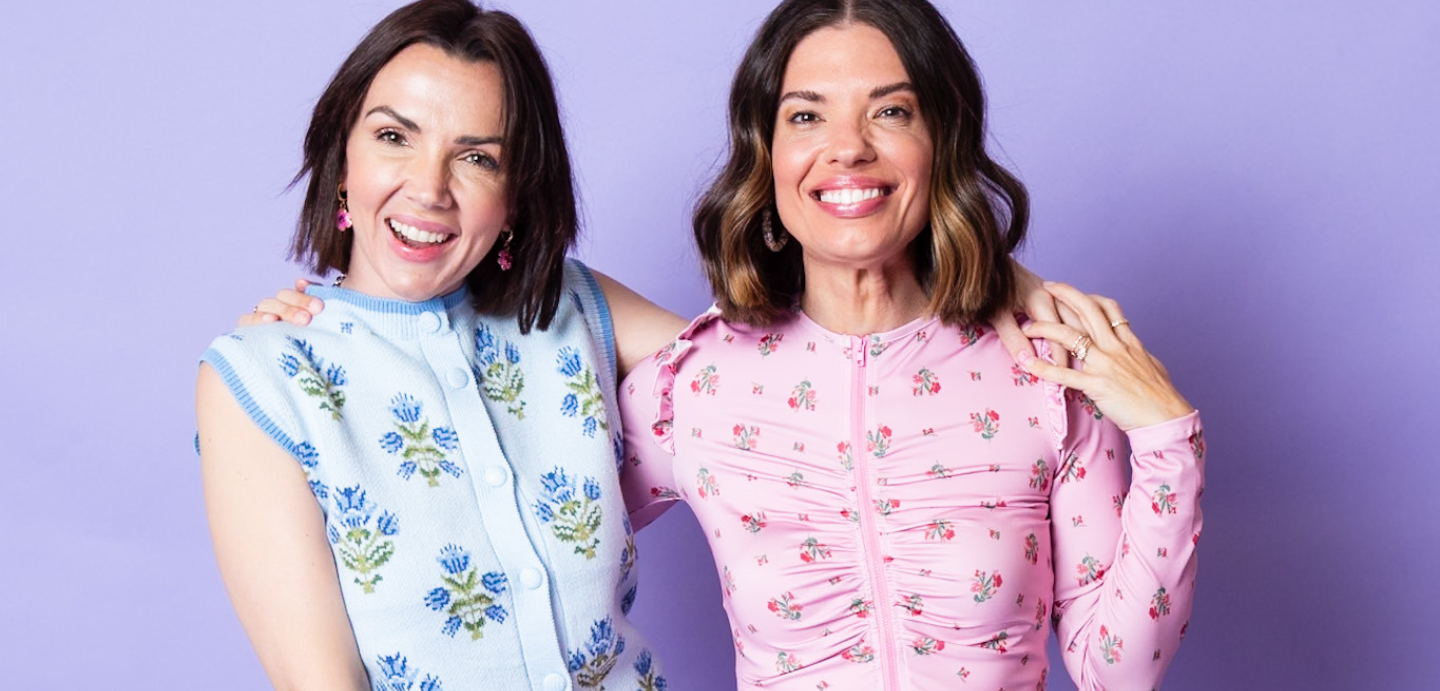 Two women smiling and embracing one another.
