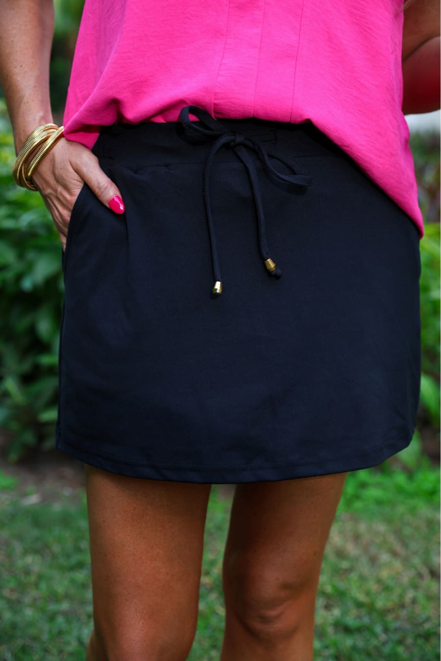 Detail of the black skort drawstring waist under a hot pink tank