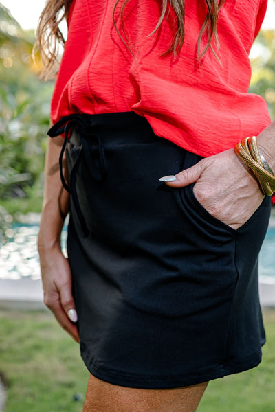 Close-up of the black skort pocket with a coral top tucked in