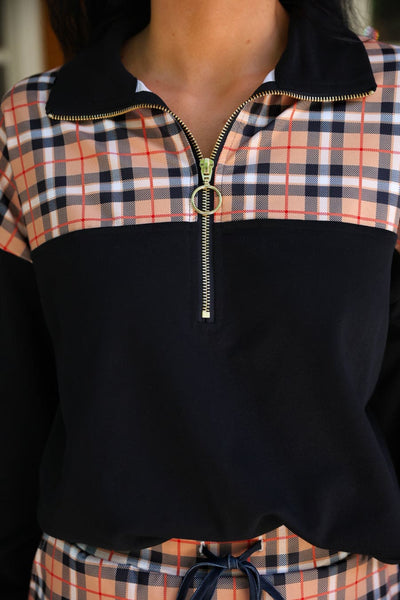 Close-up of the Nora Plaid yoke, black collar and gold ring zipper pull